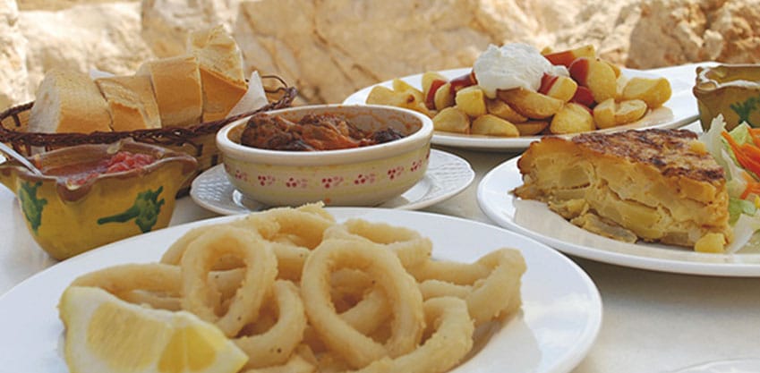 Aperitivo spagnolo accompagnato da tapas, polpo e anelli di calamari fritti