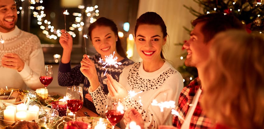 amici che festeggiano con stelle filanti a cena