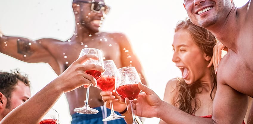 Amici festeggiano con un brindisi in costume da bagno