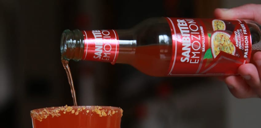 Un bicchiere di cocktail rosso con emozioni sanbitter