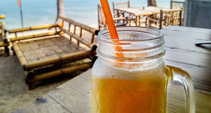 Barattolo con manico cocktail in una spiaggia tropicale