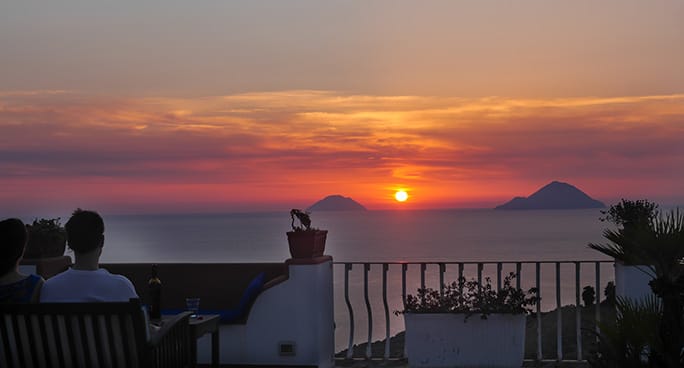 Una coppia osserva il tramonto sul mare a Lipari