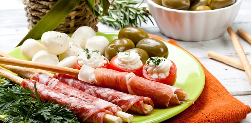 Piatto di aperitivo con salumi, olive e cipolline