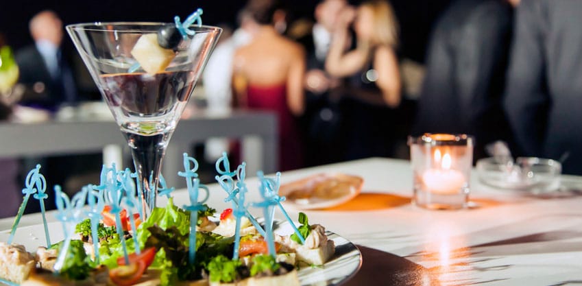 Tavolo con un piatto di stuzzichini davanti ad un cocktail