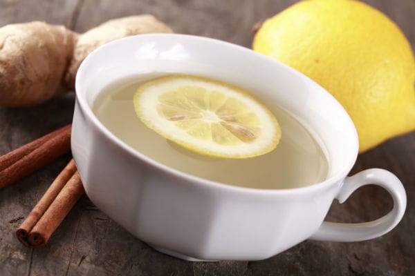 Infuso di zenzero con una fetta di limone e una stecca di cannella, una tisana purificante